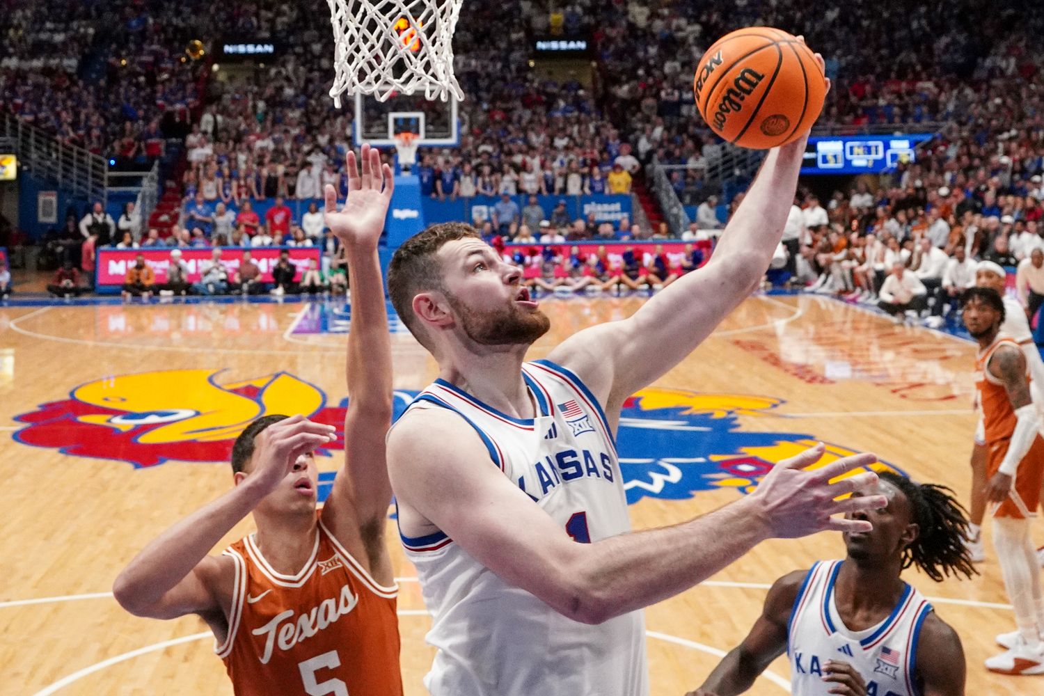 Feb 24, 2024; Lawrence, Kansas, USA; Kansas Jayhawks center Hunter Dickinson (1) shoots under the basket as Texas Longhorns forward Kadin Shedrick (5) defends during the second half at Allen Fieldhouse. Mandatory Credit: Denny Medley-USA TODAY Sports  